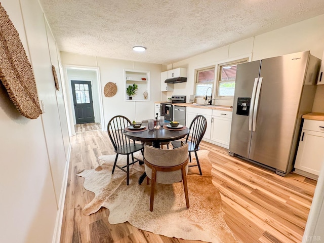 1033 8th St, Altavista, VA 24517 - dining area featuring light wood-type flooring, a textured ceiling, and healthy amount of natural light