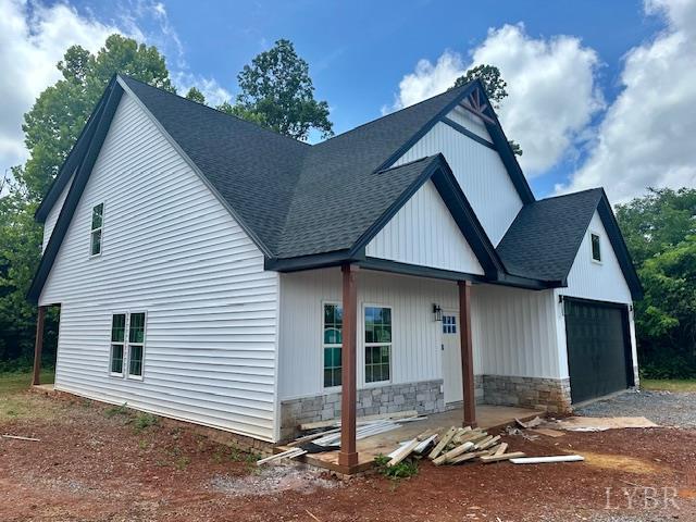 128 Riverside Dr, Lynchburg, VA 24503 - view of front facade featuring a shingled roof, a garage, driveway, and stone siding