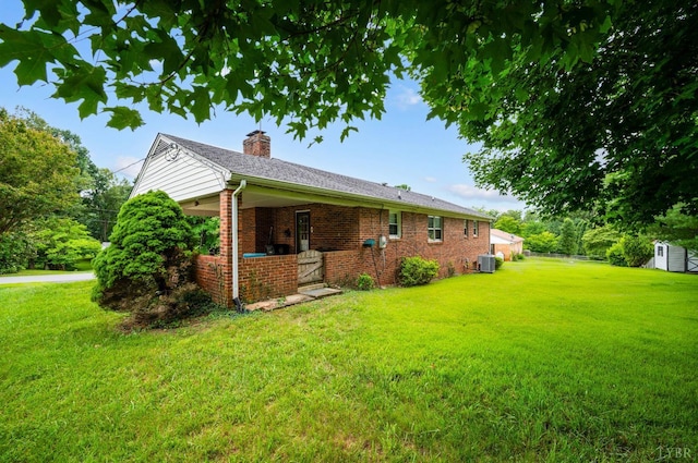 313 Robin Dr, Lynchburg, VA 24502 - view of home's exterior featuring a lawn, a chimney, brick siding, and a shed