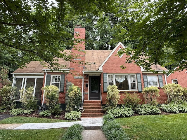 1309 Cherokee Ave, Lynchburg, VA 24502 - view of front facade with a chimney, a sunroom, roof with shingles, a front yard, and brick siding