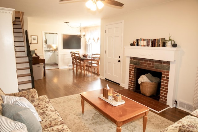 1309 Cherokee Ave, Lynchburg, VA 24502 - living room with ceiling fan, stairway, wood finished floors, a brick fireplace, and a chandelier