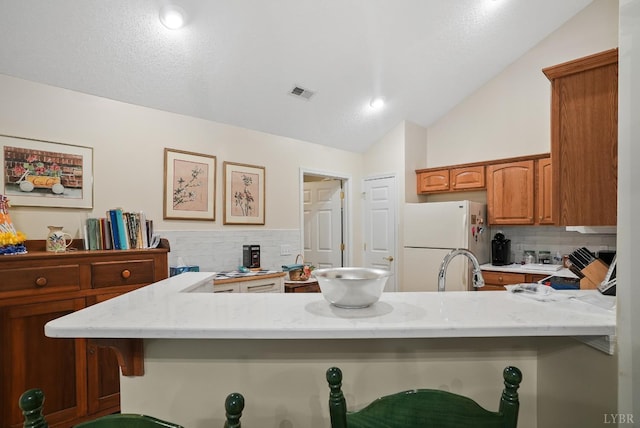 158 Salisbury Cir, Lynchburg, VA 24502 - kitchen with freestanding refrigerator, lofted ceiling, backsplash, and light stone countertops