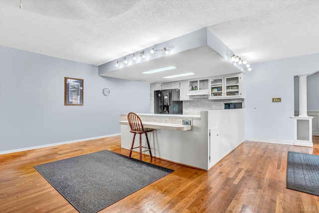 581 Ben Annie Rd, Gretna, VA 24557 - kitchen with track lighting, open shelves, a peninsula, a textured ceiling, and tasteful backsplash