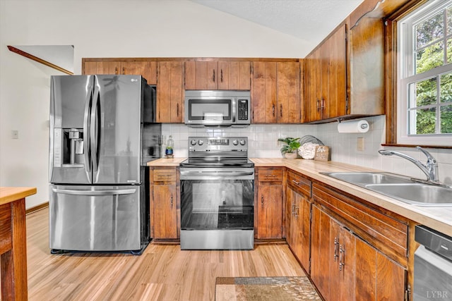 51 Laurel Ln, Lynchburg, VA 24502 - kitchen featuring appliances with stainless steel finishes, light wood-style flooring, lofted ceiling, light countertops, and brown cabinetry