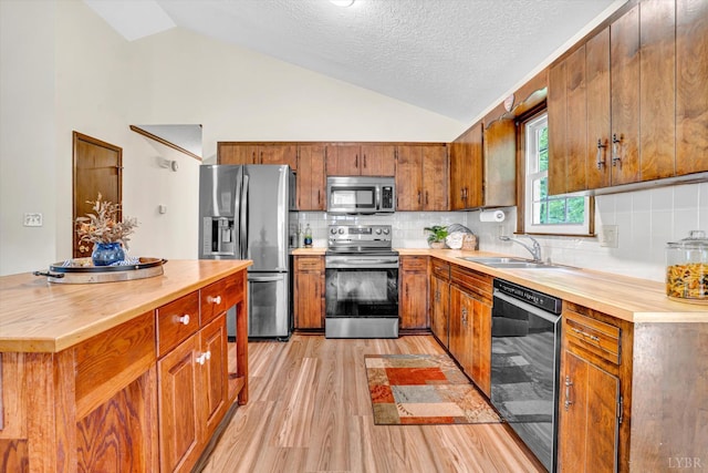 51 Laurel Ln, Lynchburg, VA 24502 - kitchen with appliances with stainless steel finishes, butcher block counters, light wood-type flooring, lofted ceiling, and brown cabinets