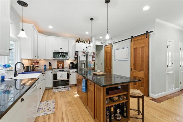 802 Lake Vista Dr, Forest, VA 24551 - kitchen with stainless steel appliances, a barn door, white cabinets, a center island, and light wood-style floors