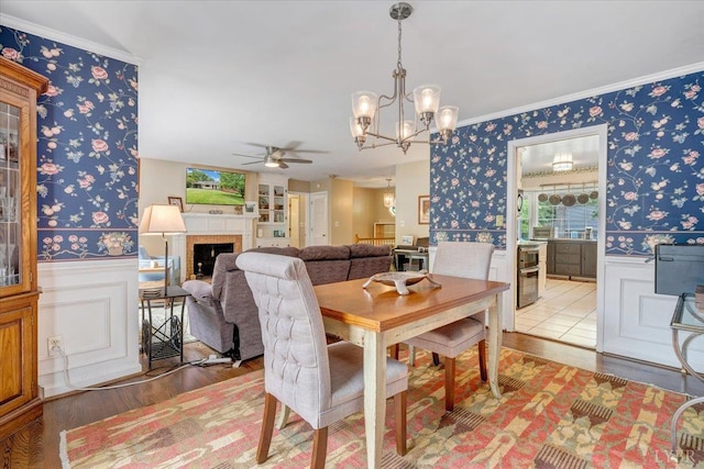 6032 Rhonda Rd, Lynchburg, VA 24502 - dining room featuring wallpapered walls, wood finished floors, ceiling fan, a wainscoted wall, and crown molding