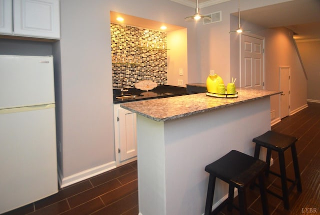 3600 Old Forest Rd Unit 113, Lynchburg, VA 24502 - kitchen featuring freestanding refrigerator, white cabinetry, dark wood finished floors, a breakfast bar, and a center island
