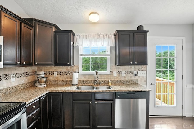 4086 Thomas Jefferson Rd, Forest, VA 24551 - kitchen featuring appliances with stainless steel finishes, backsplash, a textured ceiling, dark brown cabinetry, and light stone counters