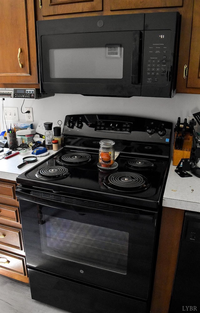 1769 Izaak Walton Rd, Madison Heights, VA 24572 - kitchen with black appliances, light countertops, and brown cabinets