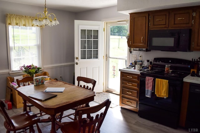 1769 Izaak Walton Rd, Madison Heights, VA 24572 - kitchen with black appliances, healthy amount of natural light, light countertops, and a chandelier