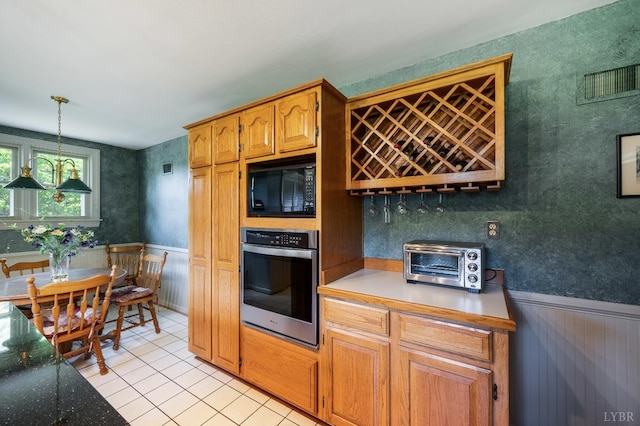 2833 Link Rd, Lynchburg, VA 24503 - kitchen featuring oven, black microwave, wainscoting, light tile patterned floors, and pendant lighting