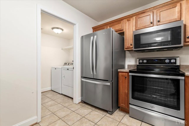 3600 Old Forest Rd Unit 107, Lynchburg, VA 24501 - kitchen featuring appliances with stainless steel finishes, separate washer and dryer, brown cabinetry, light tile patterned floors, and light countertops