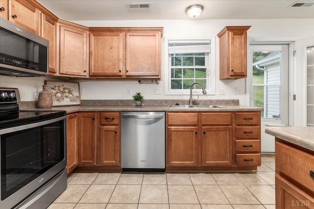 3600 Old Forest Rd Unit 107, Lynchburg, VA 24501 - kitchen with appliances with stainless steel finishes, light tile patterned flooring, and brown cabinetry