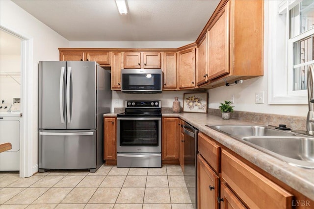 3600 Old Forest Rd Unit 107, Lynchburg, VA 24501 - kitchen featuring stainless steel appliances, washer / clothes dryer, brown cabinetry, light tile patterned flooring, and light countertops