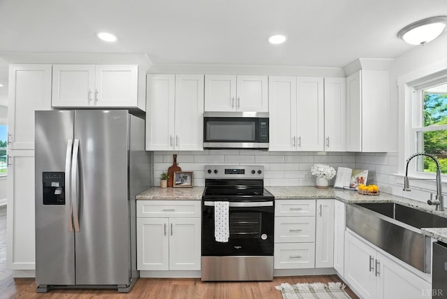 39 Lynview Dr, Lynchburg, VA 24502 - kitchen featuring stainless steel appliances, white cabinets, decorative backsplash, light wood finished floors, and light stone counters