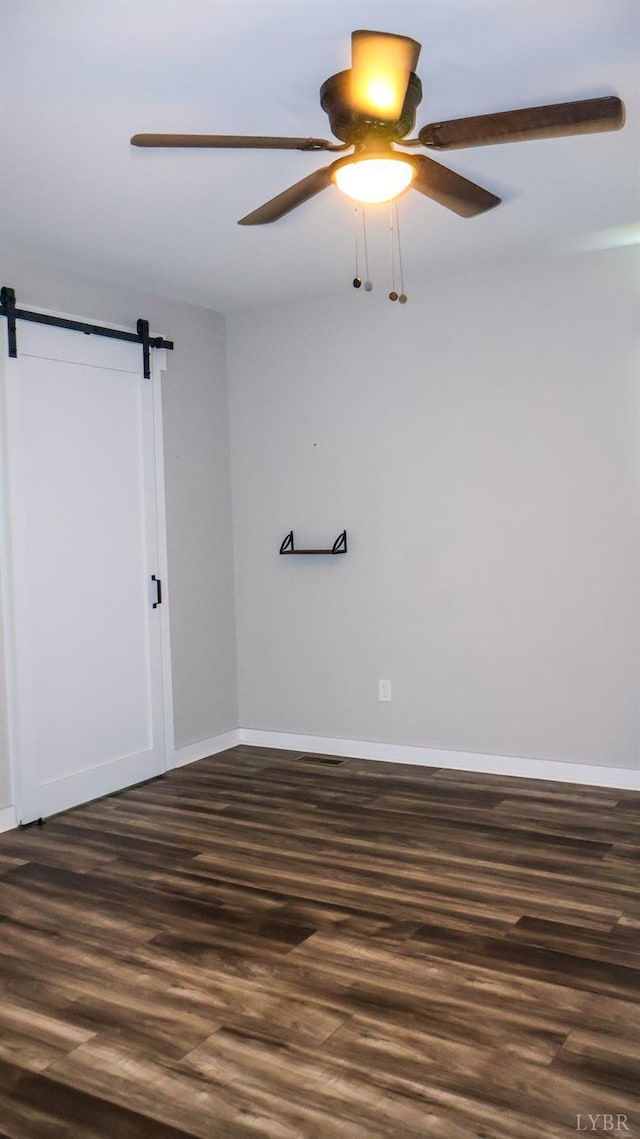 863 Winfall Rd, Gladys, VA 24554 - unfurnished room featuring a ceiling fan, dark wood-style flooring, and a barn door