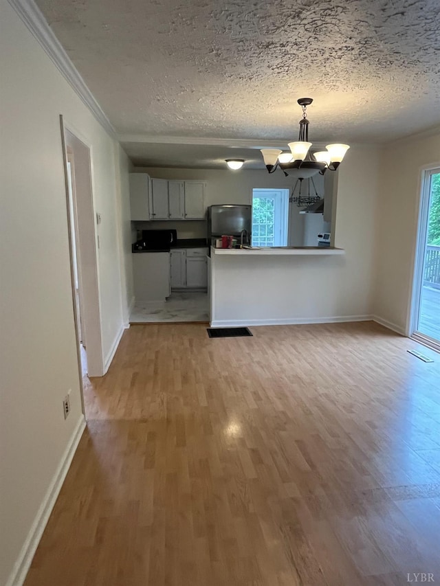 115 Primrose Ln, Lynchburg, VA 24501 - kitchen with freestanding refrigerator, a chandelier, light wood-style floors, ornamental molding, and a textured ceiling