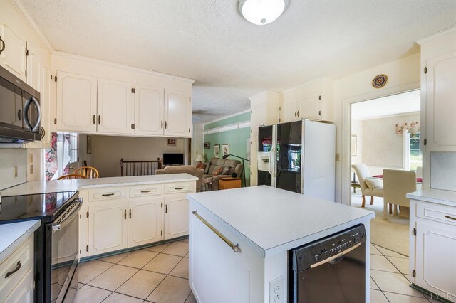 723 Custer Dr, Lynchburg, VA 24502 - kitchen featuring black appliances, light tile patterned floors, light countertops, a textured ceiling, and white cabinetry
