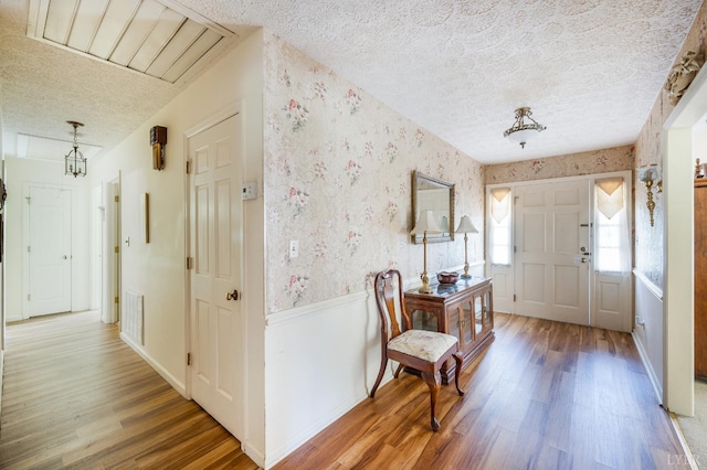 723 Custer Dr, Lynchburg, VA 24502 - foyer with a textured ceiling, wood finished floors, wallpapered walls, and a wainscoted wall