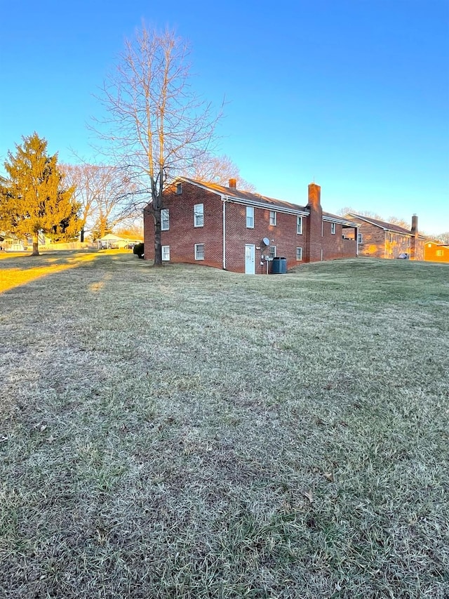 1102 Smith St, Bedford, VA 24523 - back of house featuring brick siding, a lawn, and a chimney
