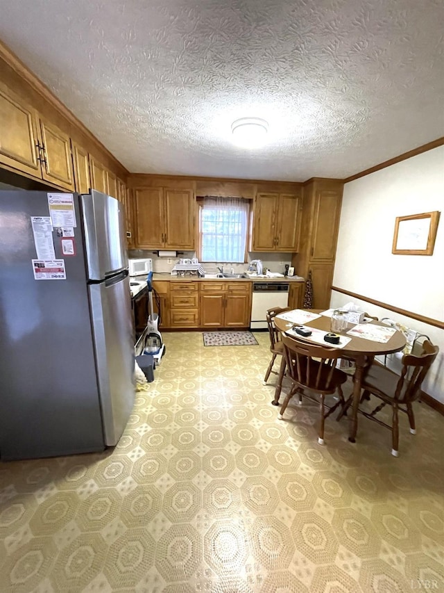 1102 Smith St, Bedford, VA 24523 - kitchen with freestanding refrigerator, white dishwasher, brown cabinets, light countertops, and a textured ceiling