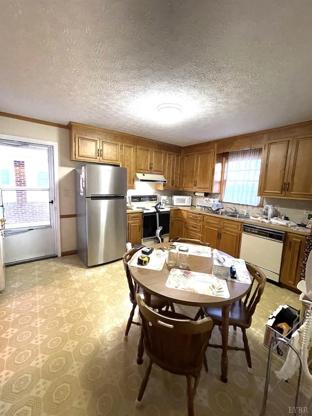 1102 Smith St, Bedford, VA 24523 - kitchen with white appliances, under cabinet range hood, brown cabinetry, light countertops, and a textured ceiling