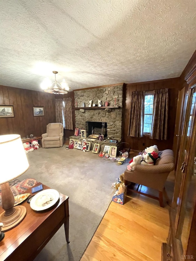 1102 Smith St, Bedford, VA 24523 - living room with a textured ceiling, wood walls, a chandelier, and a fireplace