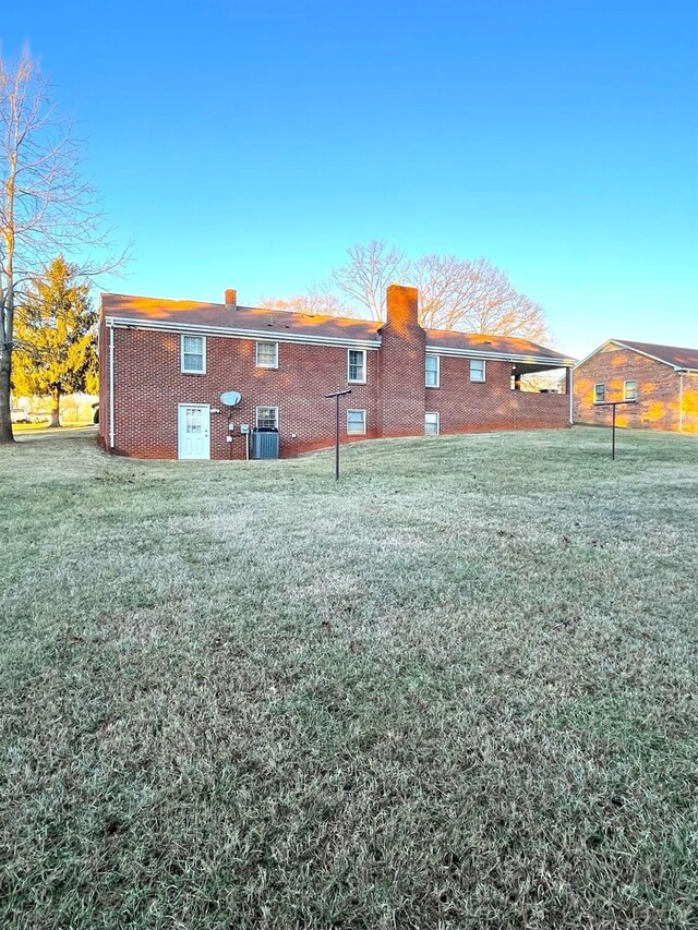 1102 Smith St, Bedford, VA 24523 - rear view of house with brick siding, a chimney, and a yard