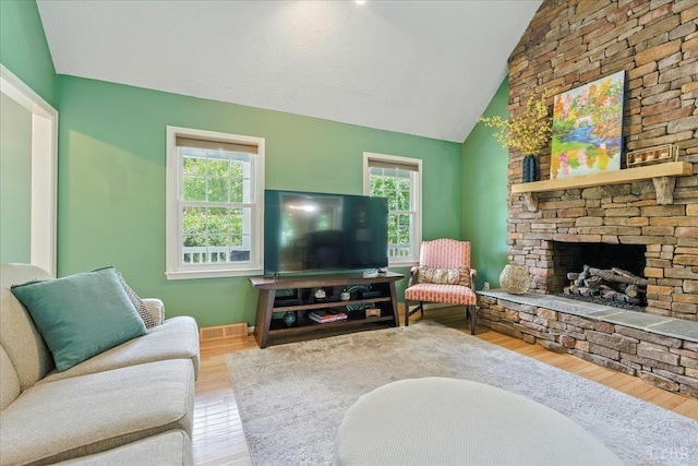 702 Kings Rd, Lynchburg, VA 24502 - living room featuring wood finished floors, healthy amount of natural light, vaulted ceiling, and a stone fireplace