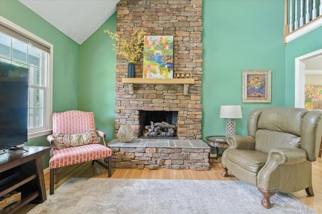 702 Kings Rd, Lynchburg, VA 24502 - living area with healthy amount of natural light, a stone fireplace, wood finished floors, and high vaulted ceiling