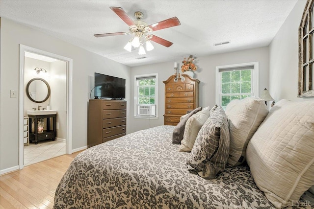 702 Kings Rd, Lynchburg, VA 24502 - bedroom featuring light wood finished floors, multiple windows, cooling unit, a textured ceiling, and a ceiling fan