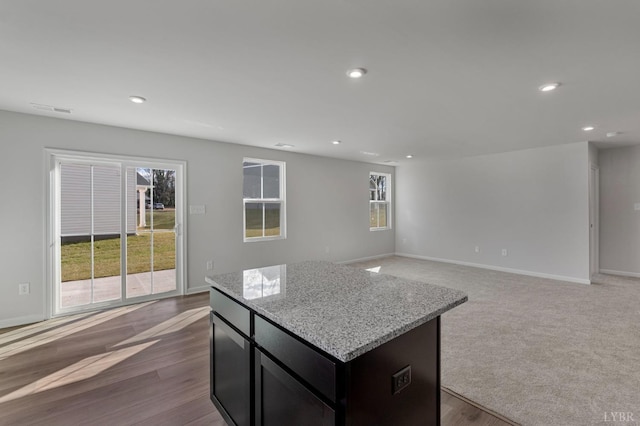 45 Levi Ln, Lynchburg, VA 24502 - kitchen featuring a kitchen island, recessed lighting, open floor plan, light stone countertops, and dark cabinets