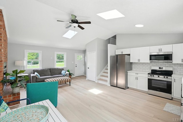 2824 Hawkins Mill Rd, Lynchburg, VA 24502 - kitchen featuring stainless steel appliances, a skylight, vaulted ceiling, a ceiling fan, and light wood-style flooring
