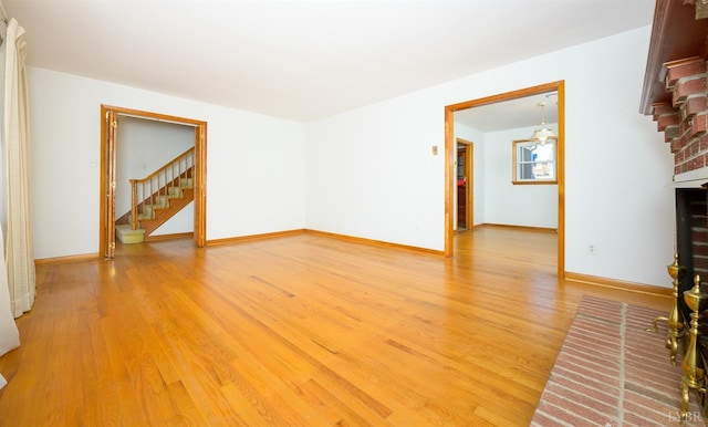 625 Sherman Dr, Lynchburg, VA 24502 - unfurnished living room featuring light wood-type flooring, stairway, and a brick fireplace