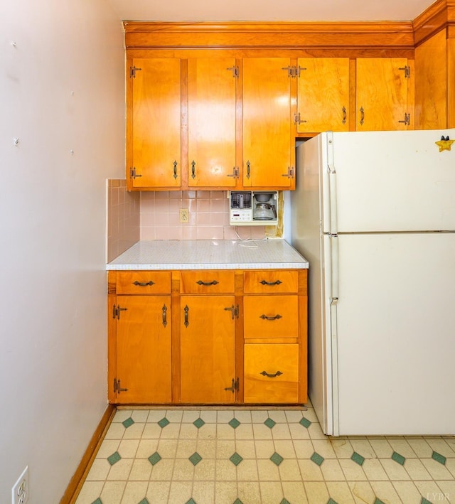 625 Sherman Dr, Lynchburg, VA 24502 - kitchen with freestanding refrigerator, light countertops, decorative backsplash, and brown cabinets