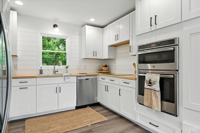 121 Brooke St, Brookneal, VA 24528 - kitchen with butcher block counters, stainless steel appliances, dark wood-style flooring, white cabinetry, and recessed lighting