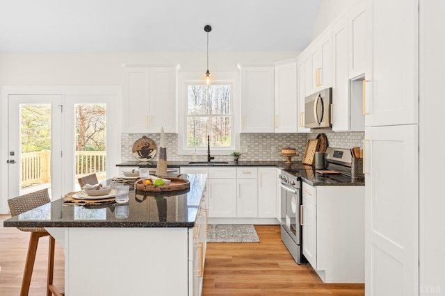 7 Hickory Cove Ln, Moneta, VA 24121 - kitchen featuring appliances with stainless steel finishes, light wood-type flooring, tasteful backsplash, and a kitchen breakfast bar