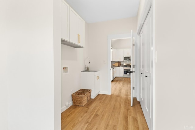 7 Hickory Cove Ln, Moneta, VA 24121 - laundry room with light wood-style floors, hookup for a washing machine, and cabinet space