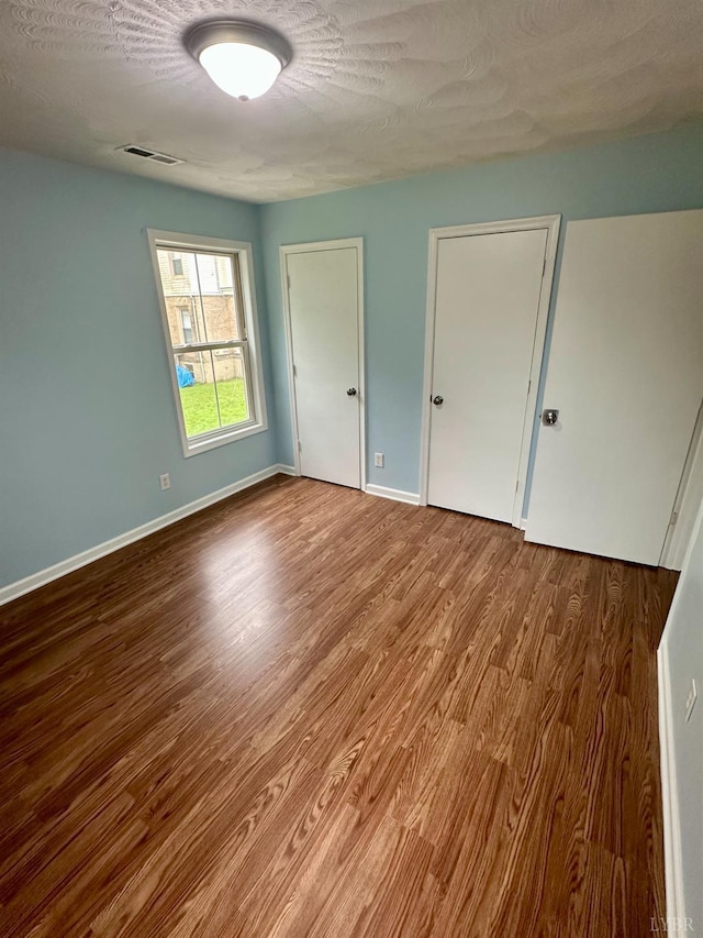 1310 9th St, Lynchburg, VA 24501 - unfurnished bedroom with wood finished floors and a textured ceiling