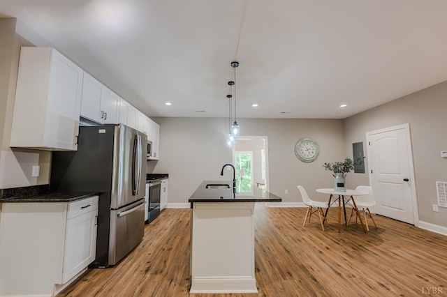 109 Tosh Ln, Goodview, VA 24095 - kitchen featuring appliances with stainless steel finishes, recessed lighting, white cabinets, light wood-style flooring, and an island with sink