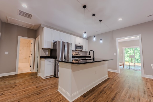 109 Tosh Ln, Goodview, VA 24095 - kitchen with stainless steel appliances, dark countertops, white cabinetry, light wood-style flooring, and a kitchen island with sink
