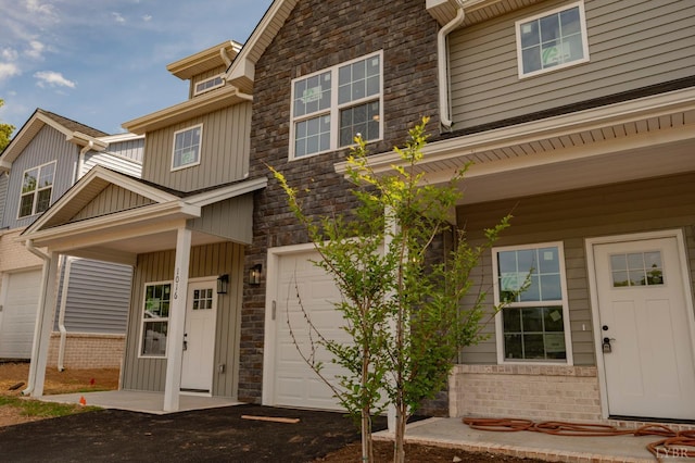 1016 Misty Mountain Rd, Lynchburg, VA 24502 - doorway to property featuring a garage, board and batten siding, stone siding, asphalt driveway, and a porch