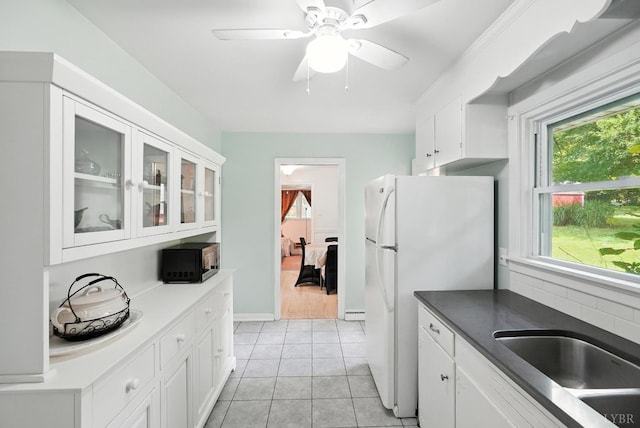 7131 Meadowbrook Rd, Lynchburg, VA 24502 - kitchen with black microwave, white cabinets, light tile patterned floors, freestanding refrigerator, and glass insert cabinets