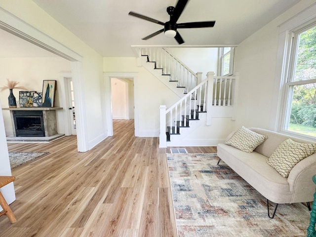 110 3rd St, Madison Heights, VA 24572 - living room with wood finished floors, stairway, ceiling fan, and a fireplace with raised hearth