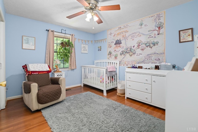 701 Goose Ridge Dr, Forest, VA 24551 - bedroom with a nursery area, wood finished floors, a ceiling fan, and a textured ceiling