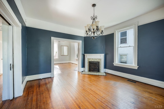 838 Rivermont Ave, Lynchburg, VA 24504 - unfurnished living room featuring a chandelier, hardwood / wood-style floors, and a stone fireplace