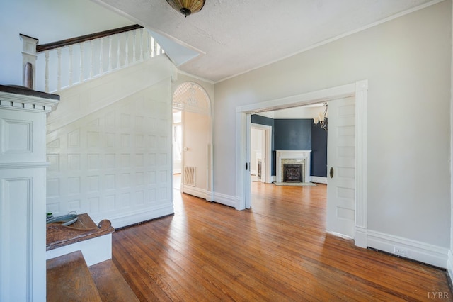 838 Rivermont Ave, Lynchburg, VA 24504 - unfurnished living room featuring hardwood / wood-style flooring, crown molding, a premium fireplace, and a chandelier