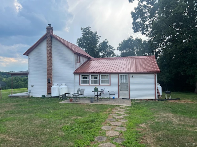 3200 Pocket Rd, Hurt, VA 24563 - back of property featuring a patio, a chimney, a yard, and a metal roof