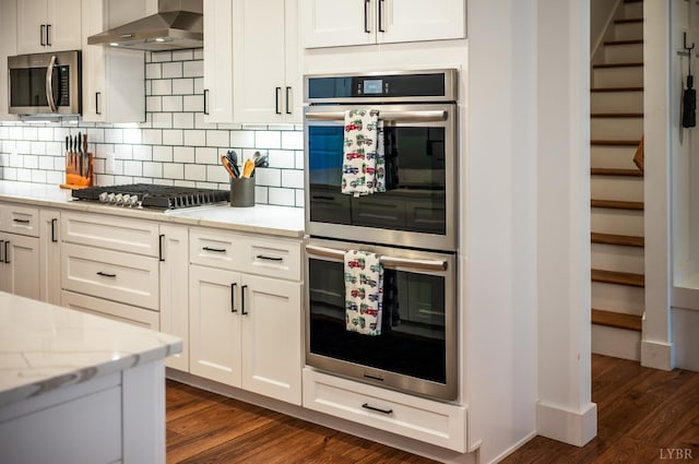 336 Somerset Dr, Appomattox, VA 24522 - kitchen with stainless steel appliances, wall chimney range hood, dark wood-style flooring, tasteful backsplash, and white cabinets